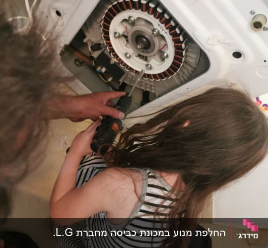 ילדה מחזיקה מברגה ליד מנוע מכשיר חשמלי